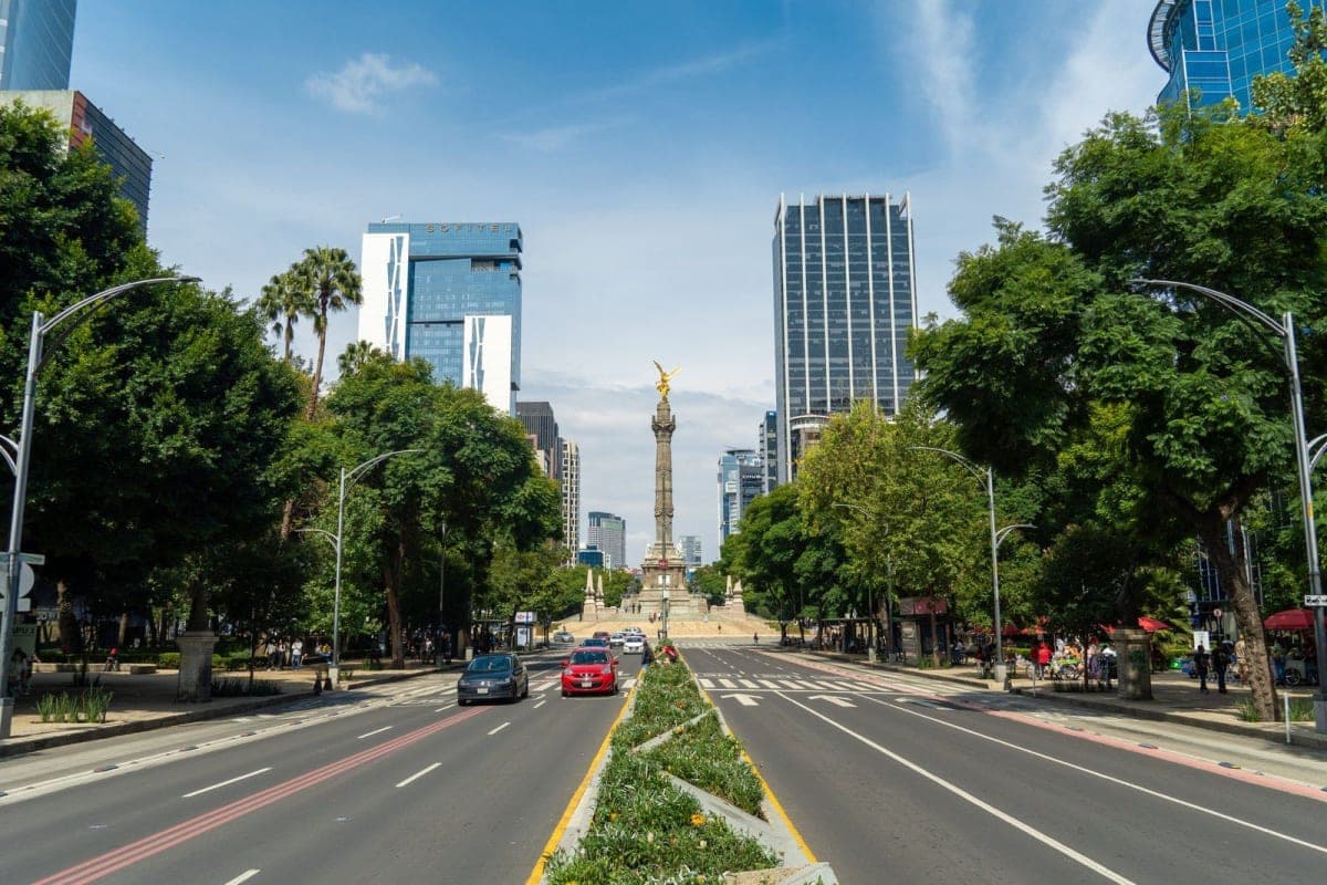 Avenida Paseo de la Reforma bordeada de árboles y torres, que conduce al Ángel de la Independencia en Ciudad de México