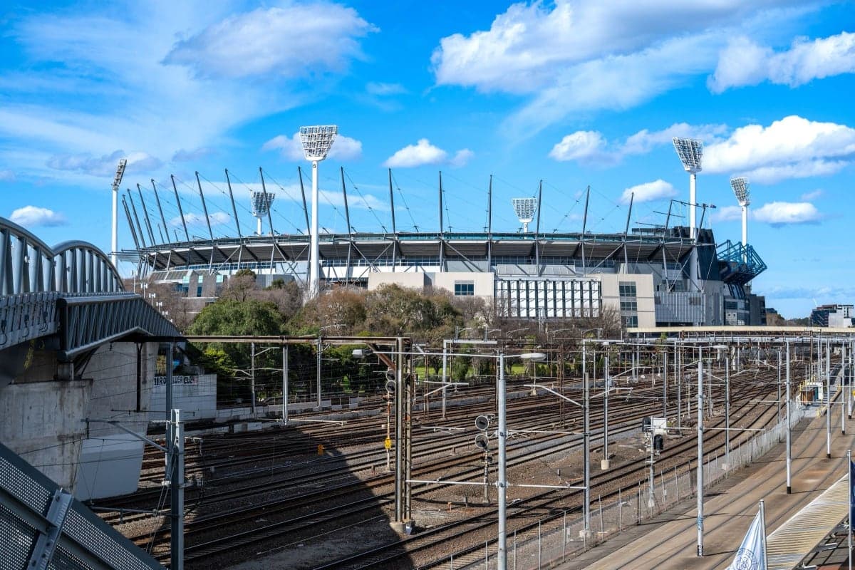 El Melbourne Cricket Ground y las vías del tren de Richmond en un día soleado, con Melbourne Park al fondo