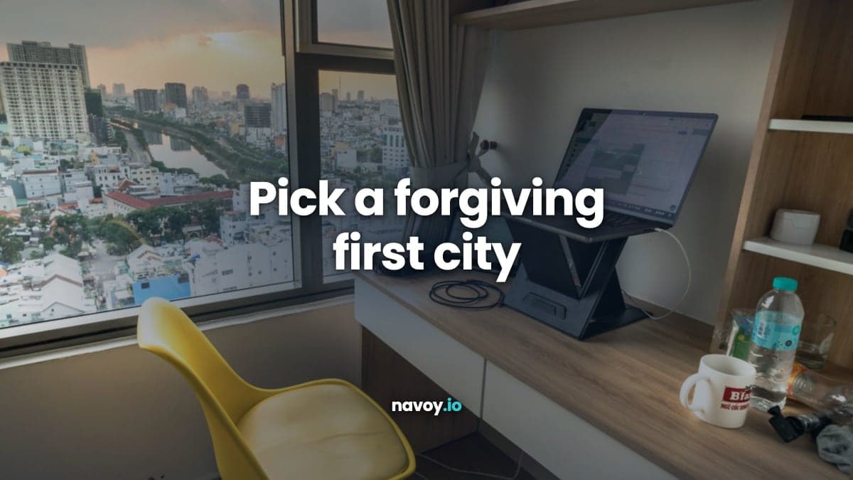 Desk with a laptop and yellow chair by a window over a city